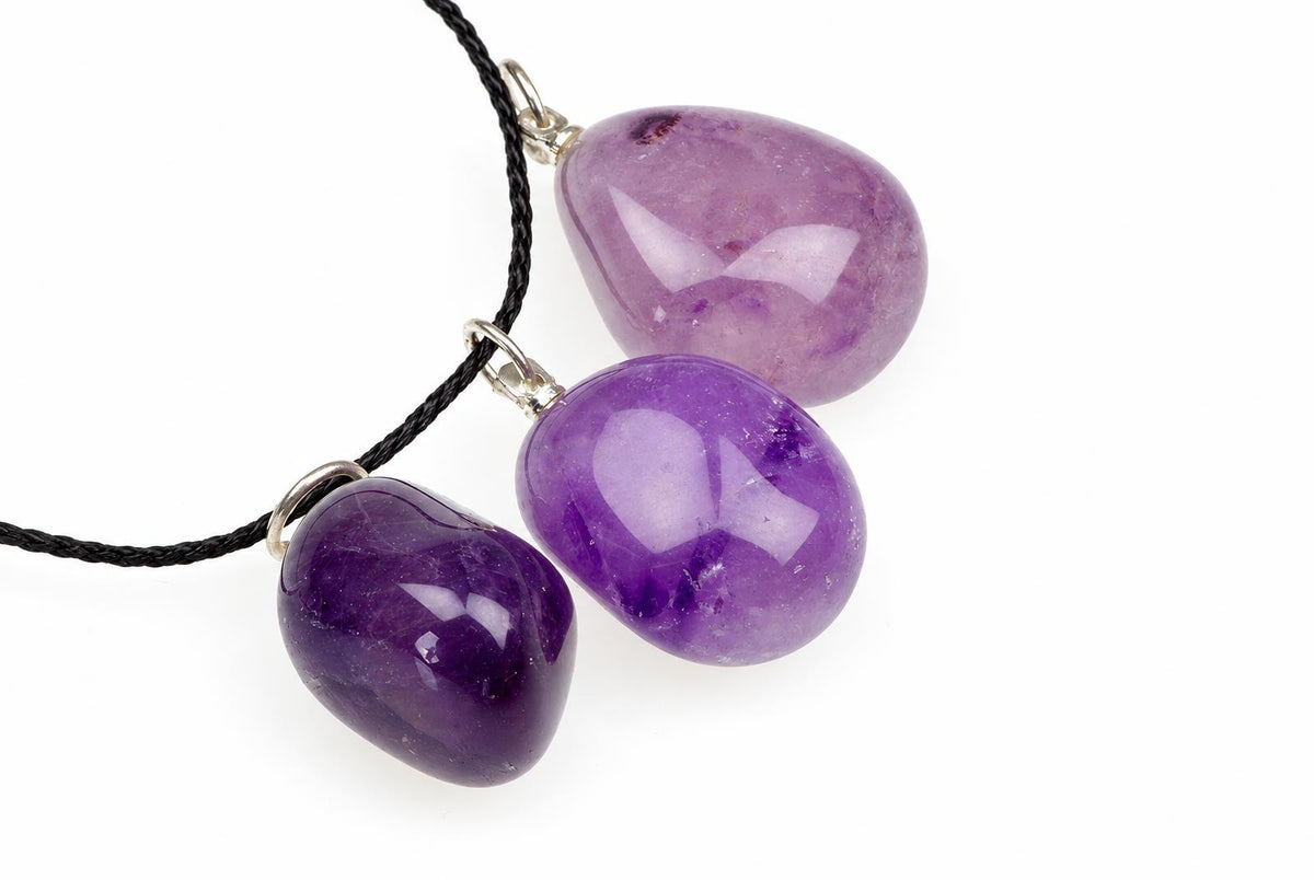 Juodas virvelis su trimis violetinėmis, apvaliomis ametisto formos pakabukais ant balto fono.