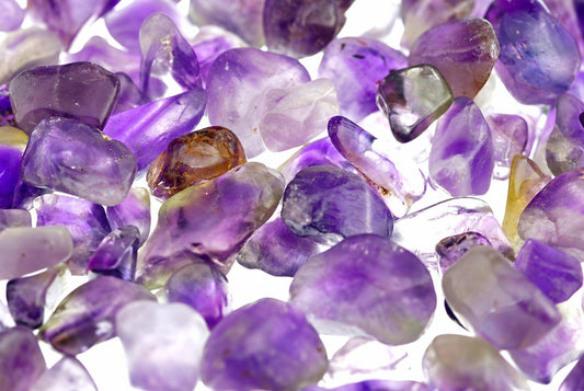 Krautuvėse išdėstyti ametišto akmenų gabaliukai su violetinėmis, baltomis ir raudonai oranžinėmis spalvomis.