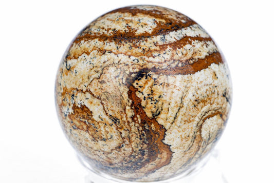 Poliruota jaspio sfera su balta, ruda ir juoda raštais ant baltos fono.