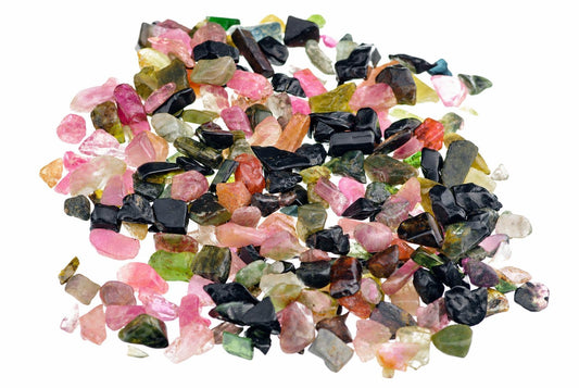 Pile of small, multi-colored tourmaline stones in pink, green, black and orange on a white background.