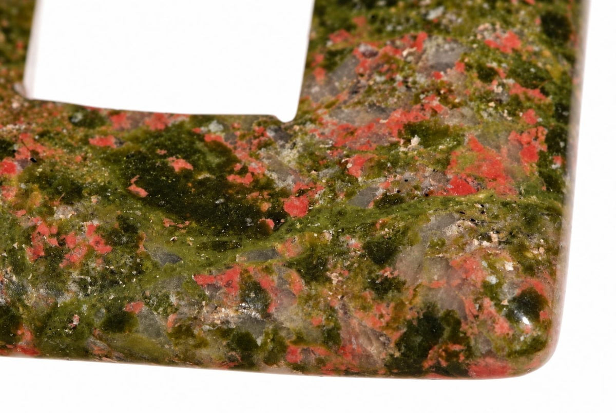 Pakabukas iš unakitito su žalia, raudona ir pilka dailia tekstūra ant balto fono.